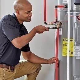 Technician connecting copper piping during a Denver water heater installation