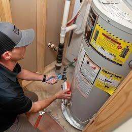 Denver technician diagnosing a water heater repair on site